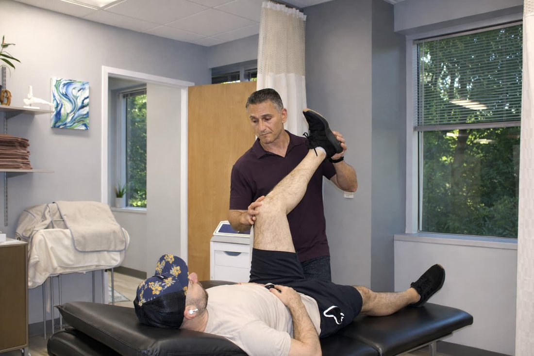 Physical therapist assessing hip flexion range during a hip impingement evaluation at a Wayne, NJ physical therapy clinic.