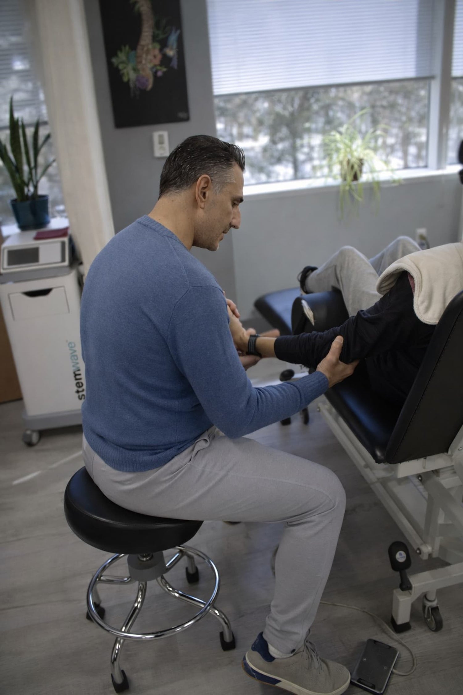 Physical therapist performing elbow mobility assessment on patient during tennis elbow treatment session