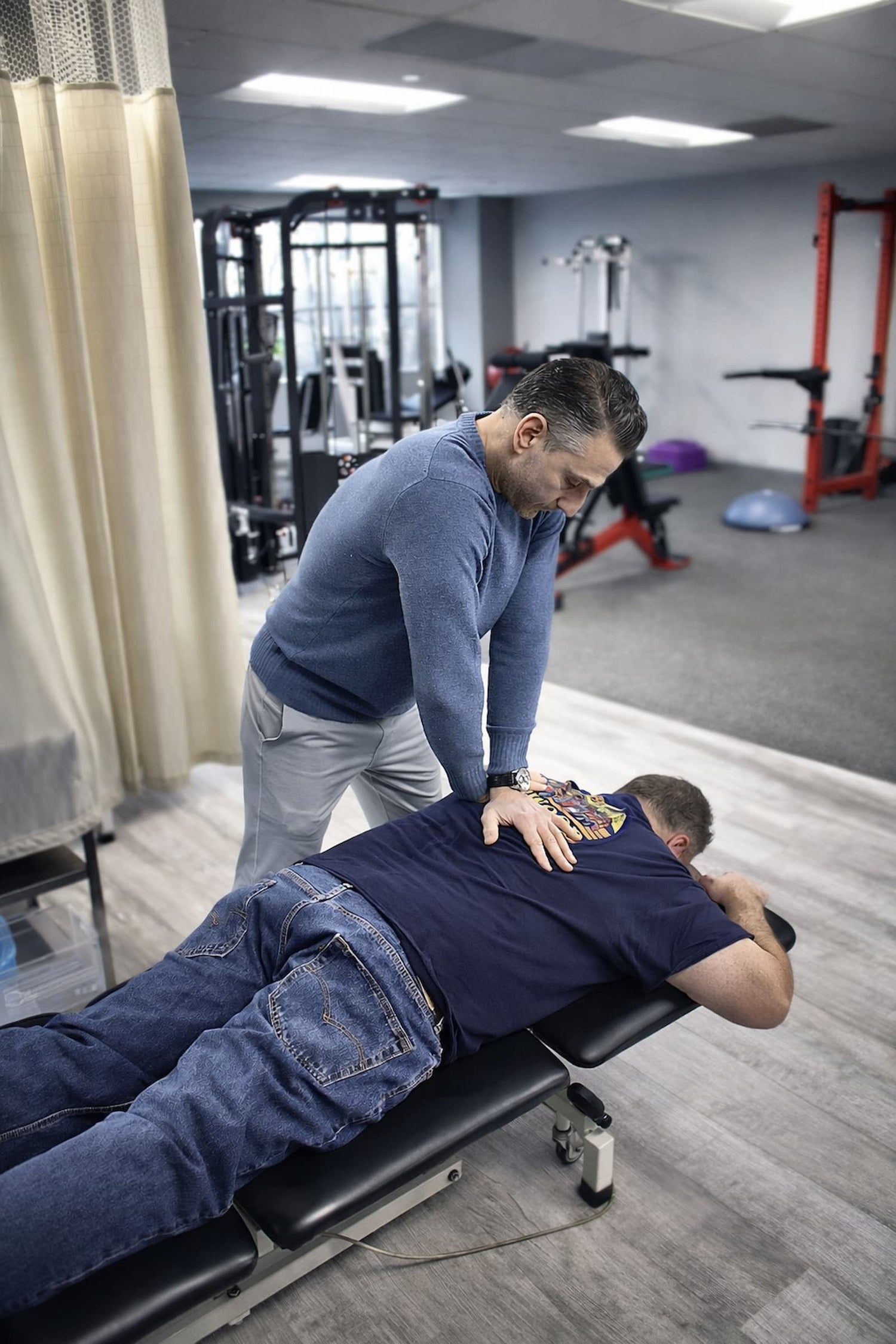 Physical therapist performing thoracic spine mobilization on patient during back pain treatment in Wayne NJ.